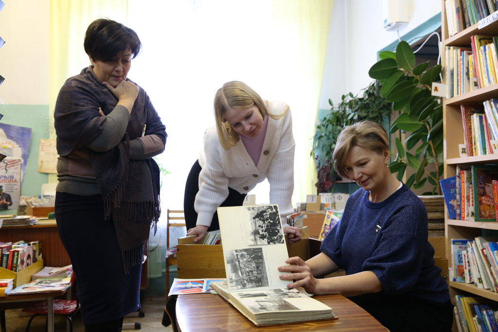 Педагоги Елена Воробьева, Юлия Молодцова и Ирина Шайхутдинова (слева направо) в школьной библиотеке. Во время экскурсии они показали нам архивные альбомы. И сами с удовольствием их порассматривали. Фото Владимира Коцюбы-Белых