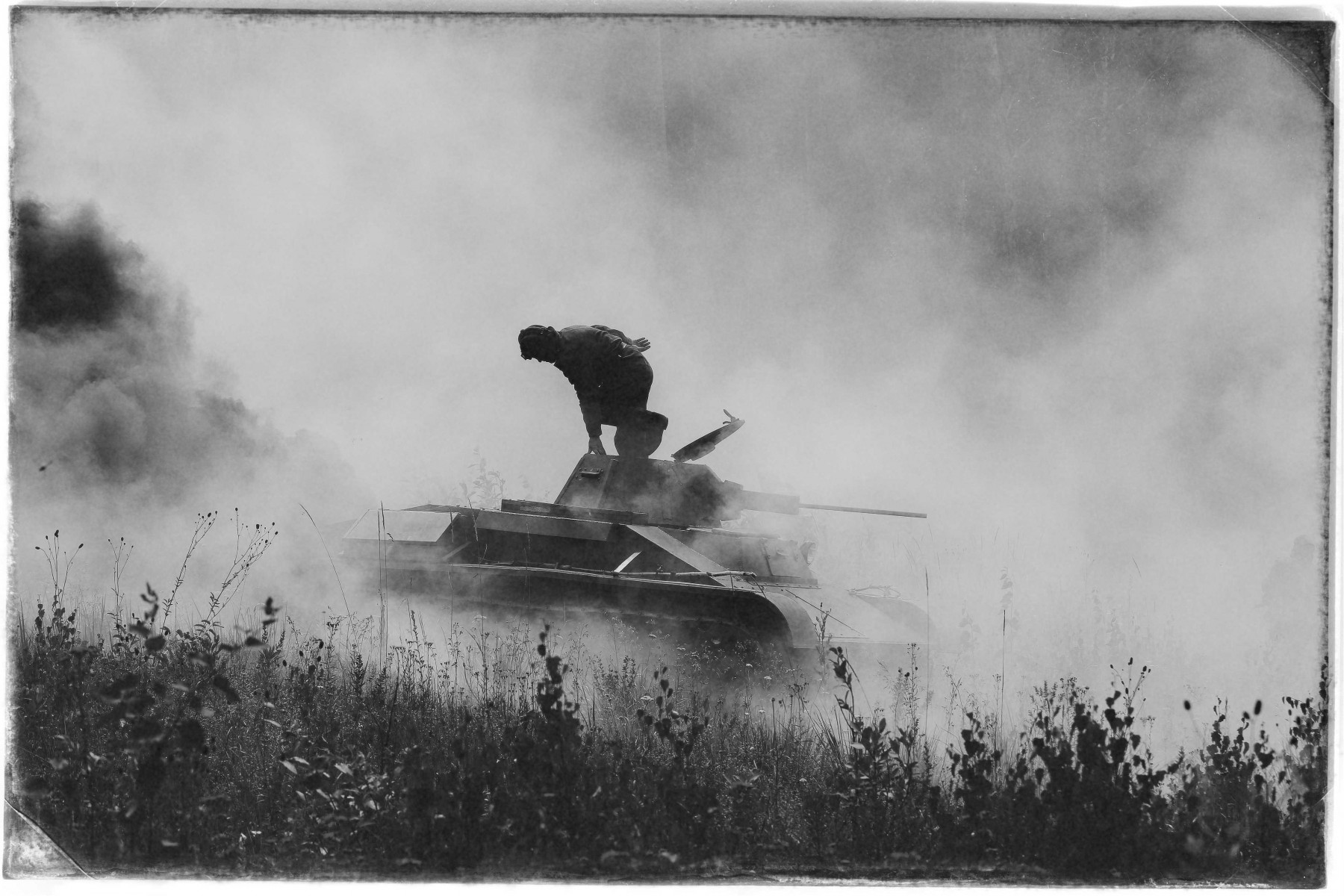 Советский танк Т-60 в клубах дыма — он подбит. Танкист покидает машину, чтобы попробовать её починить. Фото Владимира Коцюбы-Белых