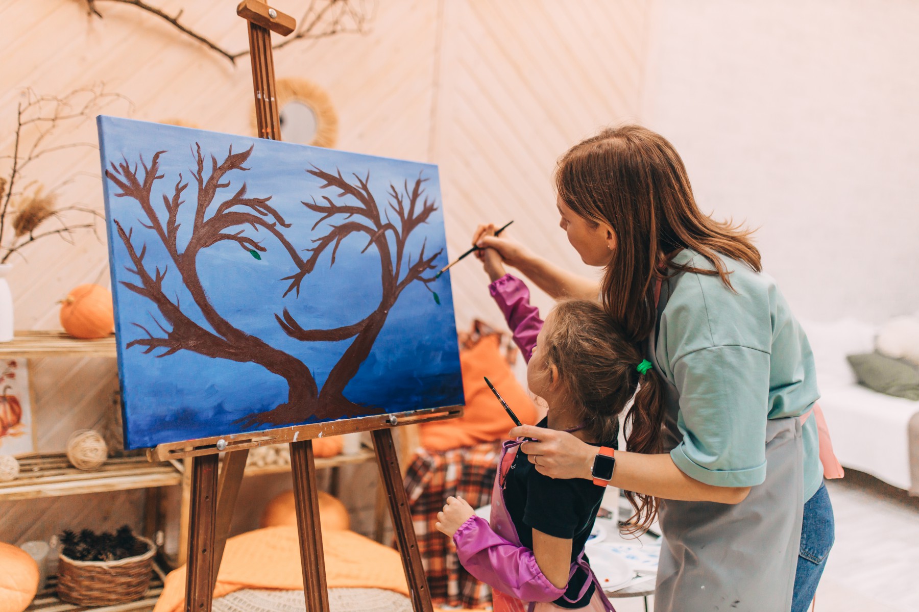 На мастер-классе по рисованию семья рисовала символическое семейное дерево. Мама Ксюша помогает дочке Ульяне рисовать листочки. Фото Альбины Крутелевой