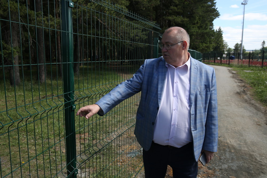 Директор ДК Виктор Ткачук показывает место, где забор уже ломали. Его оперативно отремонтировали. Фото Владимира Коцюбы-Белых