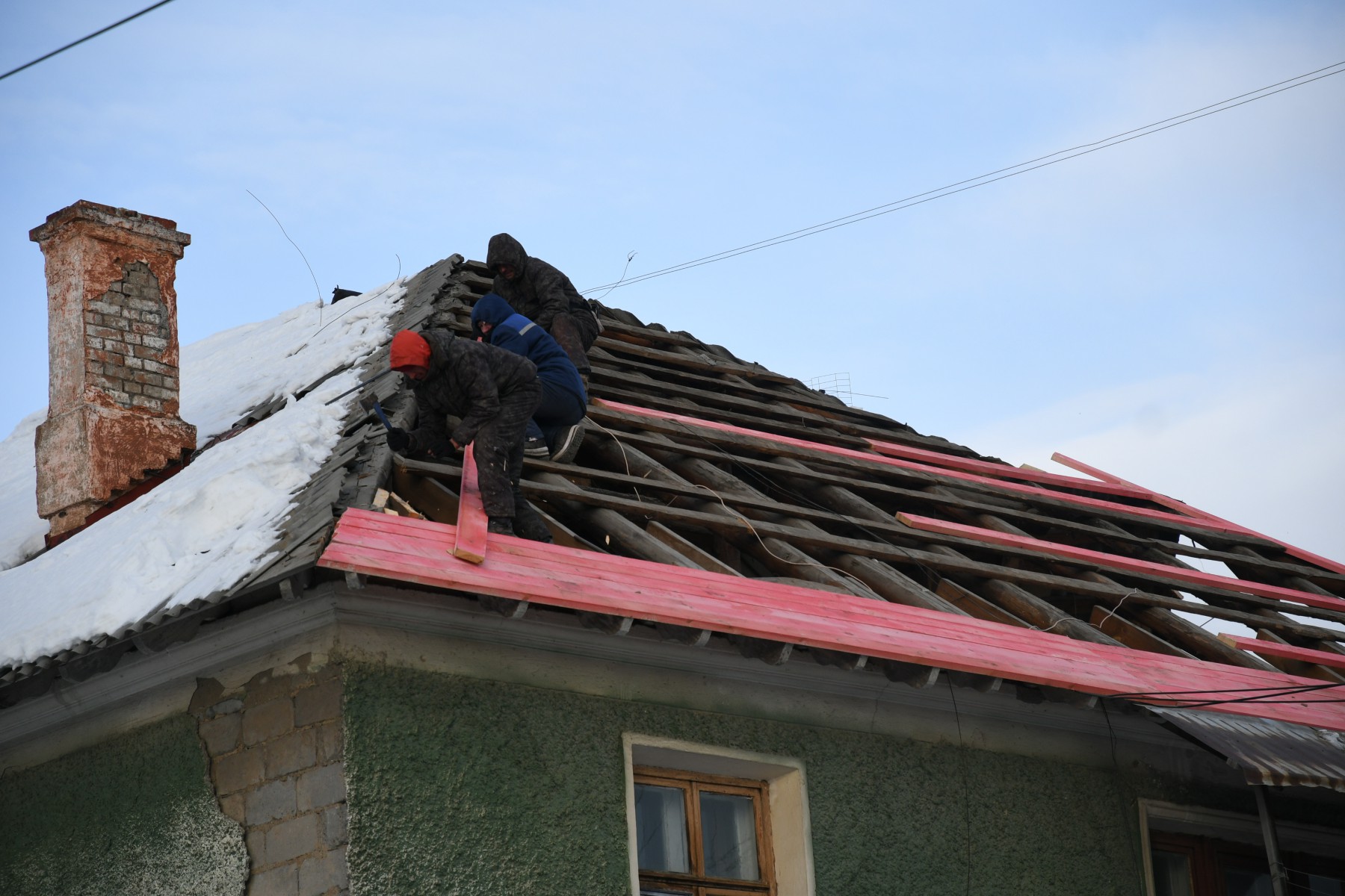 Рабочие ремонтируют кровлю дома №23 по улице Спортивной. Фото Андрея Агафонова