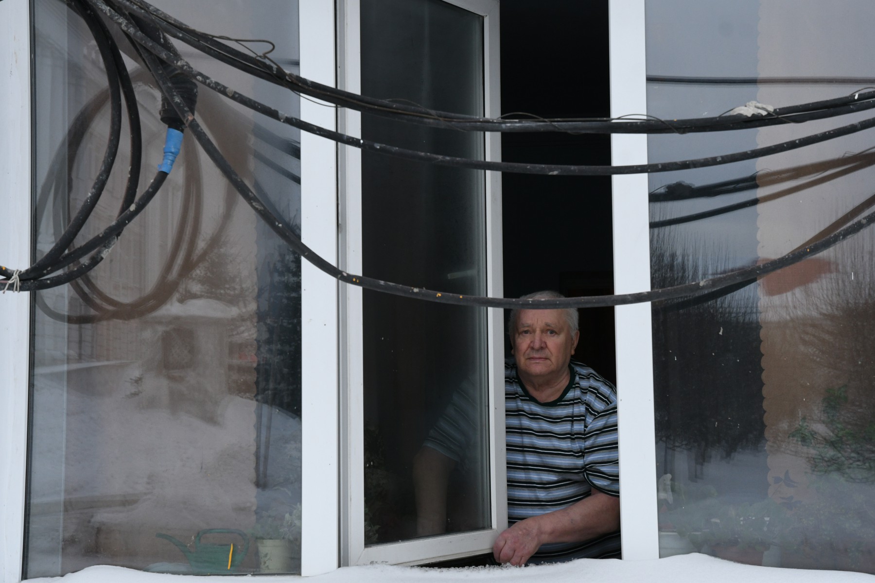 Бориса Ляпустина абсолютно не устраивает то, что сейчас напротив его окна висит вот такая связка кабеля. Фото Владимира Коцюбы-Белых