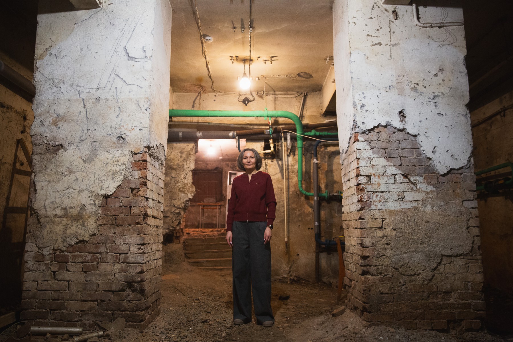 Директор гимназии Елена Калинина прошлась с нами везде, даже спустилась в подвал: «Это даже не подвал, а подкоп, он небольшой, поэтому система отопления находится под крышей гимназии. Зато здесь вот эти две древние колонны, на которых держится все здание. А еще здесь старая печечка, которая работает на угле и дровах, и даже сегодня может обогреть всю школу». // Фото Владимира Коцюбы-Белых
