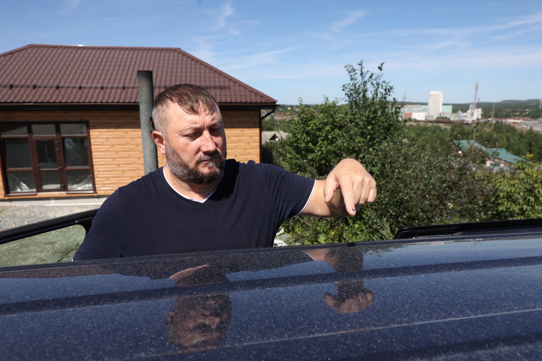 Андрей Щебров показывает налет, который прочно въелся в покрытие его машин. Известь пока не удалось удалить. // Фото Владимира Коцюбы-Белых